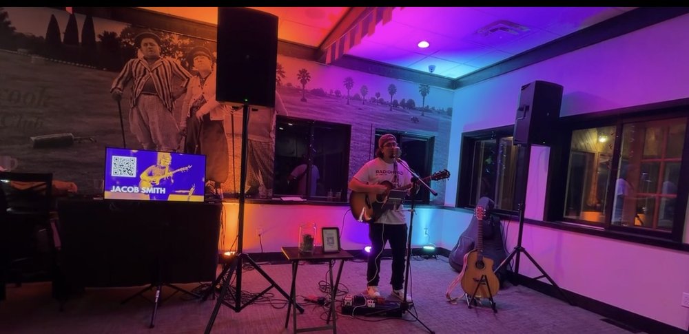 Jacob Smith performing at Willow Brook Golf Course under colorful stage lighting